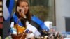 FILE - An Estonian national flag is seen as a street vendor speaks on her phone in Tallinn, Estonia, May 31, 2018.