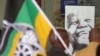 A photo of former South African president, late Nelson Mandela, right, is displayed during a remembrance ceremony in Qunu, South Africa, Saturday, Dec. 7, 2013. 