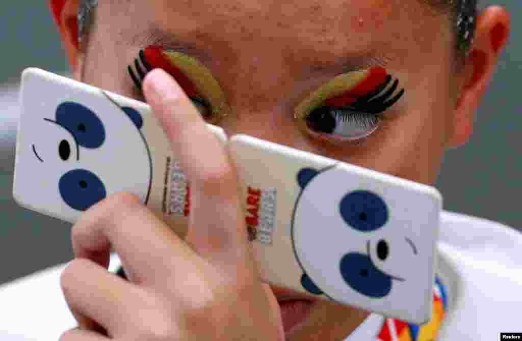 A Thai swimmer checks her makeup before the women's synchronized swimming duet free routine final of the Southeast Asian (SEA) Games at the National Aquatic Center, Kuala Lumpur, Malaysia.