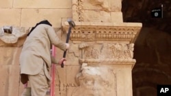 "Islomiy davlat" jangarisi qo'lida bolg'a bilan Iroqning ko'hna Hatra shahridagi obidani buzmoqda, 3-aprel, 2015-yil.