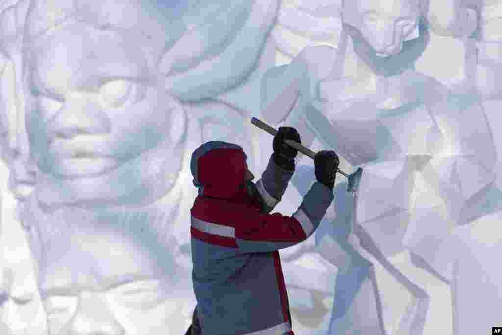 An artist works on a snow sculpture during the Harbin International Snow Sculpture Contest at the Harbin Ice and Snow World in Harbin, China's Heilongjiang province, Jan. 8, 2025. 