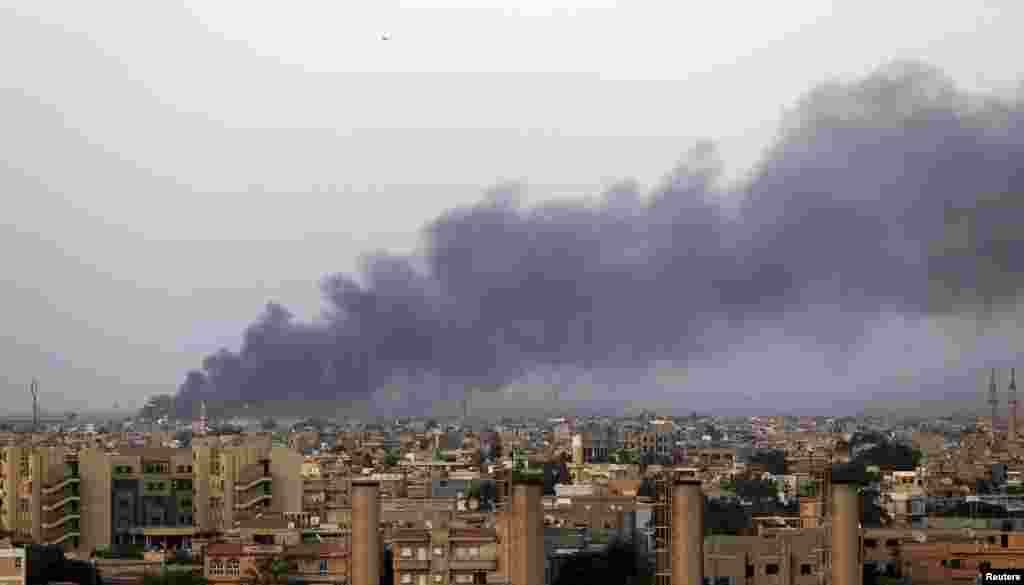 Bing'ozi inqilobchilari sho'ro kengashi jangchilari hamda general Xalifa Haftar tarafdorlari o'rtasida bo'lib o'tgan janglardan so'ng osmonga qora tutun o'rladi, 23-avgust, 2014-yil.