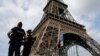 FILE - French police patrol near the Eiffel tower as part of security measures in Paris, France, July 13, 2017. 
