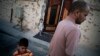 FILE - A Libyan family stands next to their house within Area 2 in Sirte , Libya, July 16, 2012. Sirte, the hometown of the country's late dictator Moammar Gadhafi and the last regime stronghold to fall during the revolution.