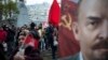 Communist Party supporters stand next to a monument to Karl Marx, left, and hold Soviet flags and portraits of Soviet founder Vladimir Lenin, right, during a demonstration marking the 100th anniversary of the 1917 Bolshevik Revolution in Moscow, Russia, Nov. 7, 2017.