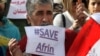 Syrian Kurds hold posters during a demonstration outside of the UN office in the northern Iraqi city of Arbil, against a military operation by the Turkish army against the Kurdish YPG forces in Syria's Afrin, Jan. 23, 2018. 