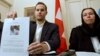 FILE - Christine Levinson (right), wife of former FBI agent Robert Levinson, watches as her son Daniel Levinson displays a web print of his father's picture to journalists while attending a news conference at Switzerland's embassy in Tehran, Dec. 22, 2007