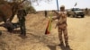A fighter with the Tuareg separatist group MNLA (National Movement for the Liberation of Azawad) brandishes a separatist flag for the region they call Azawad outside the local regional assembly, where MNLA members met with the Malian army, the U.N. missio
