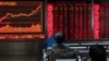 Investors monitor stock prices at a brokerage in Beijing, Jan. 16, 2020. Share prices are mixed in moderate trading in Asia after the U.S. and China signed a preliminary trade agreement.