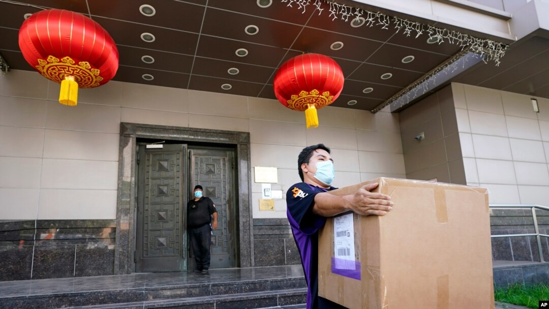 A FedEx employee removes a box from the Chinese Consulate in Houston, July 23, 2020.