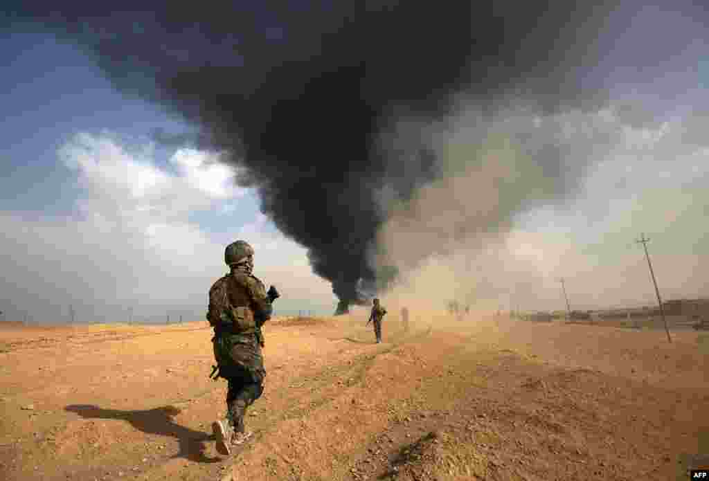 Iraqi forces and members of the Hashed al-Shaabi (Popular Mobilization units) advance towards the city of al-Qaim, in Iraq&#39;s western Anbar province near the Syrian border as they fight against remnant pockets of Islamic State group jihadists.