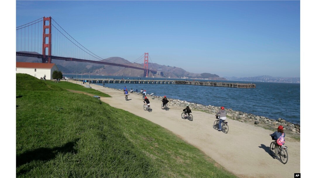 FILE - In this Nov. 25, 2014, photo, bicyclists ride past Crissy Field near the Golden Gate Bridge in San Francisco. Federal authorities have approved a politically conservative group's application to hold a rally at Crissy Field on Aug. 26.