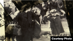 Nazi photo of Jewish boy surrendering as Nazi troops force Jews out of the Warsaw ghetto in April 1943, displayed at Yad Vashem's "Flashes of Memory" exhibition in Jerusalem, January 24, 2018.