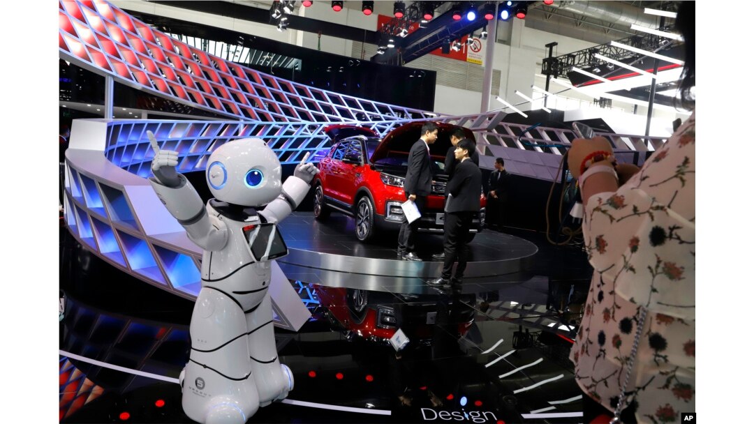 FILE - A robot entertains visitors at the booth of a Chinese automaker during the China Auto 2018 show in Beijing, China, April 26, 2018. Under President Xi Jinping, a program known as "Made in China 2025" aims to make China a tech superpower by advancing development of industries that in addition to semiconductors include artificial intelligence, pharmaceuticals and electric vehicles.
