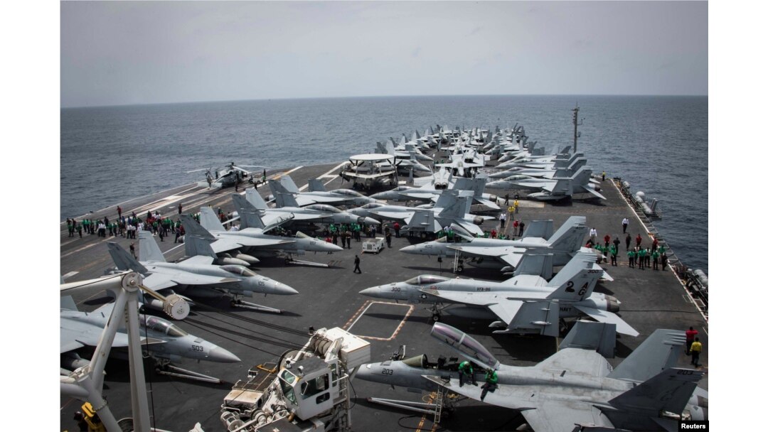 Sailors check for foreign objects and debris on the flight deck of the Nimitz-class aircraft carrier USS Abraham Lincoln in the Arabian Sea, May 19, 2019.