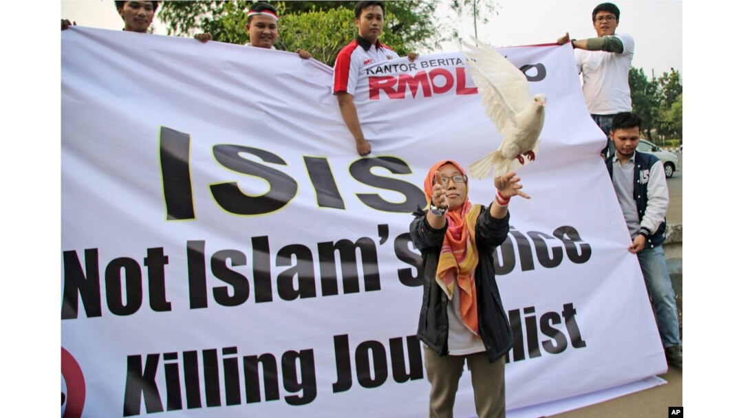 FILE - A woman releases a dove as a symbol of peace during a rally against the Islamic State group, in Jakarta, Indonesia, Sept. 5, 2014.