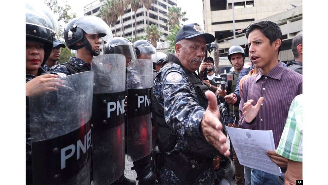 A police officer blocks an opponent to Venezuela's President Nicolas Maduro outside the Navy's headquarter in Caracas, Venezuela, May 4, 2019. Opposition leader Juan Guaido took his quest to win over Venezuela's troops back to the streets.