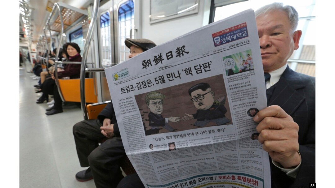 A passenger reads a newspaper with headline of a planned summit meeting between North Korean leader Kim Jong Un and U.S. President Donald Trump, left, at subway train in Seoul, South Korea, March 10, 2018. The White House tried to swat away criticism Frid