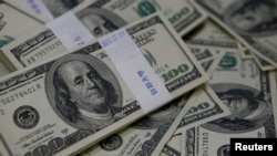FILE - Bundles of U.S. $100 bills, Aug. 2, 2013. 