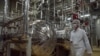 FILE - An Iranian security official in protective clothing walks through part of the Uranium Conversion Facility just outside the Iranian city of Isfahan in this undated photo.
