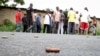 A man takes a picture of spent bullet casings lying on a street in the Nyakabiga neighborhood of Bujumbura, Burundi, Dec. 12, 2015. Burundi erupted into protests and violence in April 2015 after President Pierre Nkurunziza sought what many viewed as an unconstitutional third term.