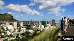 FILE - A tour guide stands with a group of tourists at a viewpoint overlooking Port Louis on June 6, 2008. Mauritius took the top spot once again in annual index.