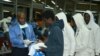 FILE - Cameroonian migrants receive registration forms upon their arrival after spending several months in Libya, at the Yaounde International Airport in Cameroon, Nov.r 22, 2017.