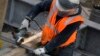 FILE - Sparks fly as a construction worker uses a grinder to cut through steel reinforcing bars in New York, Feb. 1, 2016. 