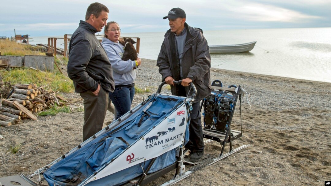FILE - In this Sept. 2, 2015 file photo President Barack Obama meets with John Baker, left, the 2011 Iditarod winner on Kotzebue Shore Avenue, which has dealt with erosion problems, in Kotzebue, Alaska. On Dec. 9, 2016, Obama used his executive powers to add protections to waters off Alaska's west coast. Obama will leave behind a host of disputed actions and unfinished business on the environment, from blocked energy leases and mining projects to recent pollution restrictions and decisions on hundreds of potentially-imperiled species. Republicans emboldened by Donald Trump's victory are gearing up to reverse many of the administration's signature environmental moves.