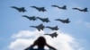FILE - A man watches Russian military jets performing in Alabino, outside Moscow, Russia, Aug. 12, 2017. Russia's planned ‘Zapad 2017’ exercises on the border with Baltic states and Poland are viewed with suspicion by NATO alliance members. 