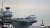 The Royal Navy's new aircraft carrier, HMS Queen Elizabeth, is towed by tugs as it arrives at Portsmouth Naval base, its new home port, in Portsmouth, Britain, Aug. 16, 2017.