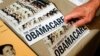 A Tea Party member reaches for a pamphlet titled "The Impact of Obamacare", at a Tea Party Rally in Littleton, New Hampshire, Oct. 27, 2012