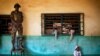An African Union peacekeeper stands on a chair as a small child sits of the floor at an Islamic center where Peul refugees have sought protection in Bangui, Central African Republic, Dec. 18, 2013.