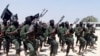 FILE - Hundreds of newly trained al-Shabab fighters perform military exercises near Mogadishu, Somalia. 