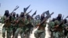 FILE - Al-Shabab fighters are seen marching with their weapons during exercises on the outskirts of Mogadishu, Somalia. 