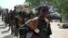 FILE - A youth leads a group of hard-line Islamist Al Shabab fighters as they conduct military exercises in northern Mogadishu's Suqaholaha neighborhood, Somalia, Jan. 1, 2010. 