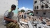 A Somali man watches the damage caused at the scene where a car exploded in the Madina district of Mogadishu, Somalia, May 17, 2017. 