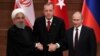 FILE - Presidents Hassan Rouhani of Iran, Recep Tayyip Erdogan of Turkey and Vladimir Putin of Russia hold a joint news conference after their meeting in Ankara, Turkey, April 4, 2018.