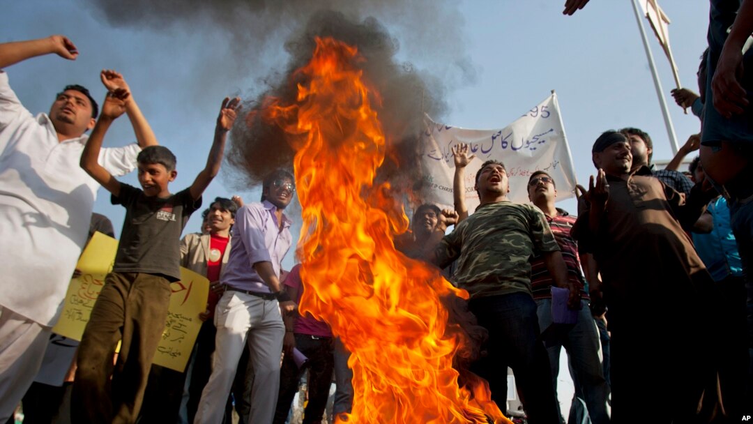 Pakistani Christians chant slogans after they burn a tire during a demonstration demanding that the government rebuild their homes after they were burned down following an alleged blasphemy incident, in Islamabad, Pakistan, March 10, 2013.