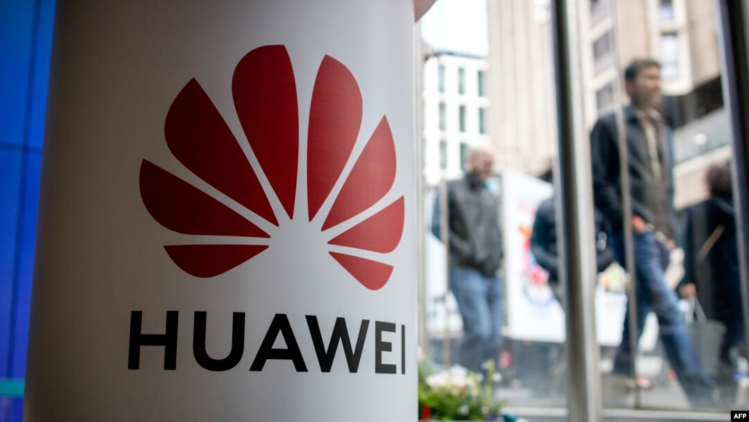A pedestrian walks past a Huawei product stand at an EE telecommunications shop in London, April 29, 2019
