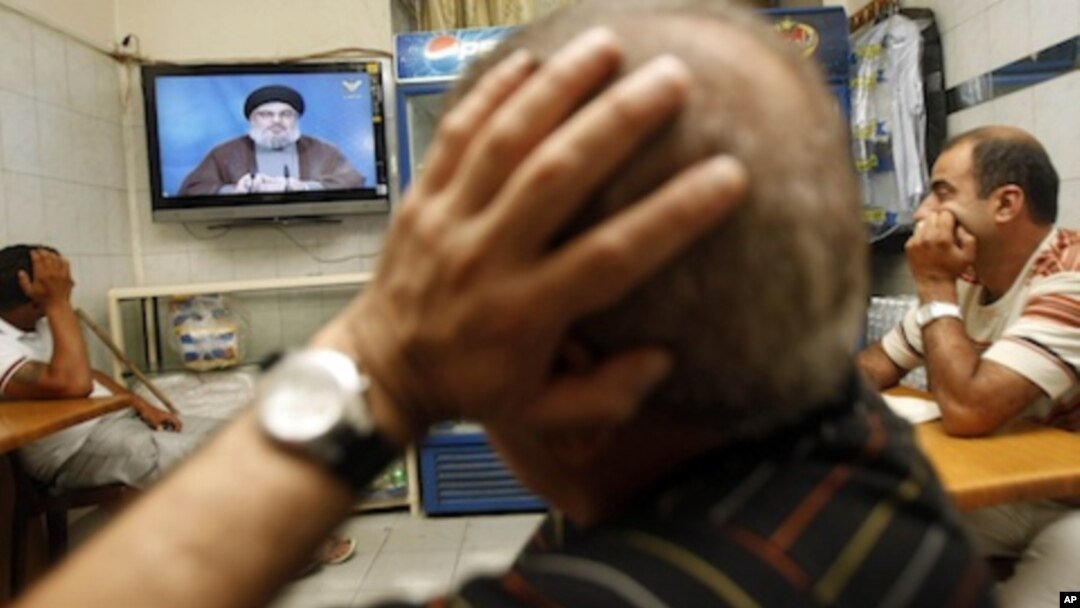 Lebanese watch Hezbollah's leader Hassan Nasrallah as he speaks in a televised address at a cafe in Beirut, Lebanon, Saturday, July 2, 2011.