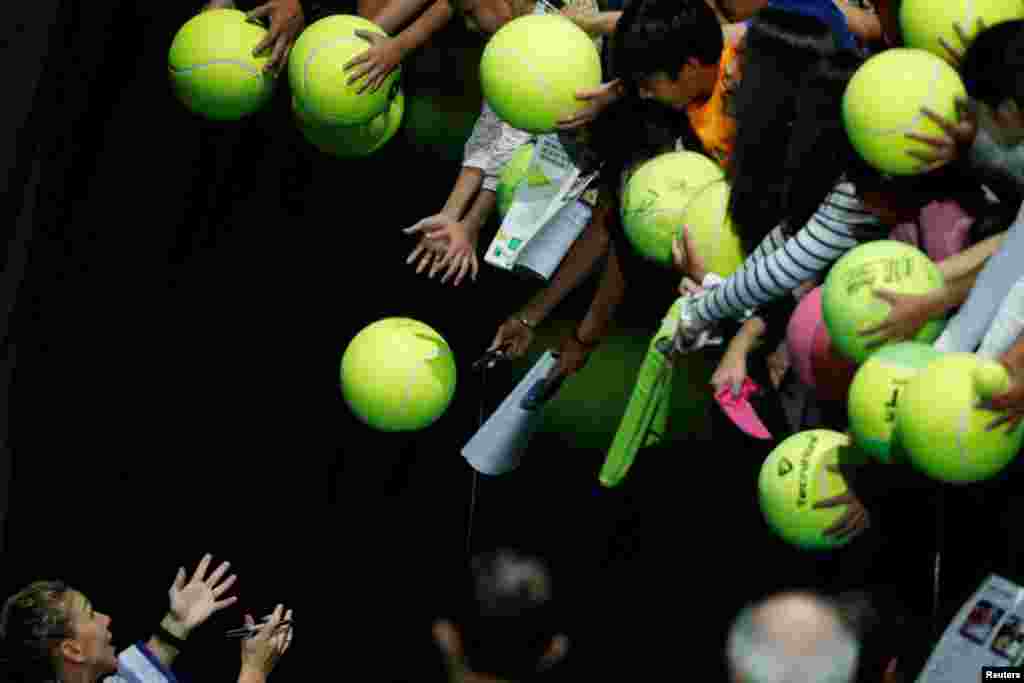 Romania's Simona Halep prepares to sign autographs for spectators, after winning her group stage match with France's Caroline Garcia during the WTA Finals tennis tournament at the Singapore Indoor Stadium.