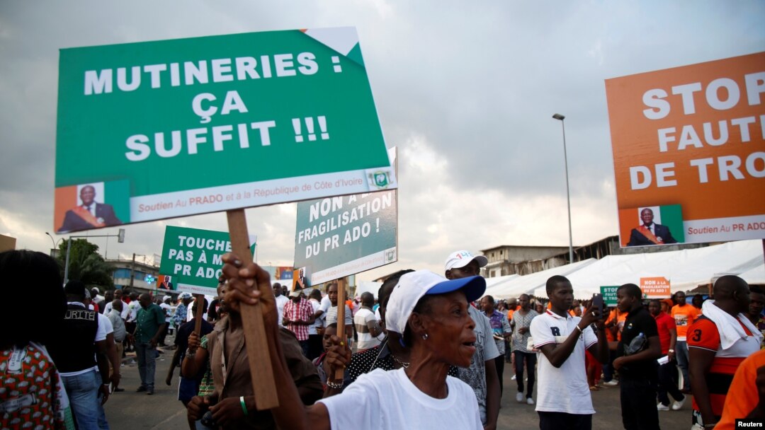 A partisan of the ruling party RDR (Rally of the republicans) holds a placard during a rally against the mutiny close to the military headquarters in Abidjan, Ivory Coast, May 13, 2017. The placard reads, "Mutinies: it's enough". 