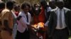Human rights lawyer Nicholas Opio, seen (left) in this file photo carrying one of her clients, has been arrested on Dec. 22, 2020. (Photo: H. Athumani/VOA)
