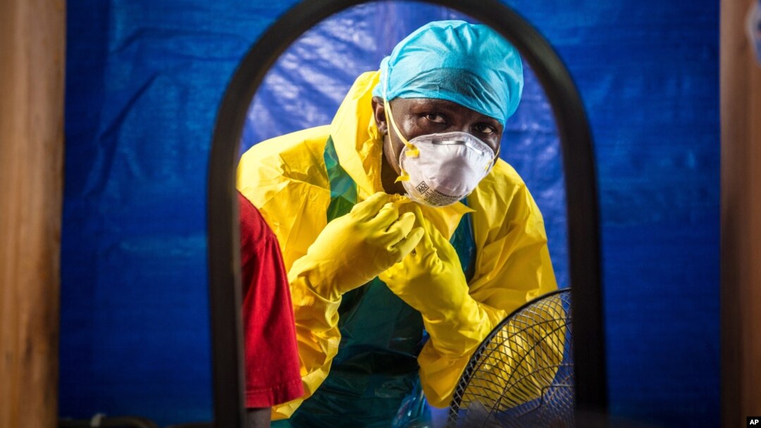FILE - A health care worker dons protective gear before entering an Ebola treatment center in Freetown, Sierra Leone, Oct. 16, 2014.