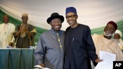 Nigeria's President Goodluck Jonathan, center-left, and opposition candidate Gen. Muhammadu Buhari, center-right, hug and shake hands after signing a renewal of their pledge to hold peaceful "free, fair, and credible" elections, at a hotel in Abuja.