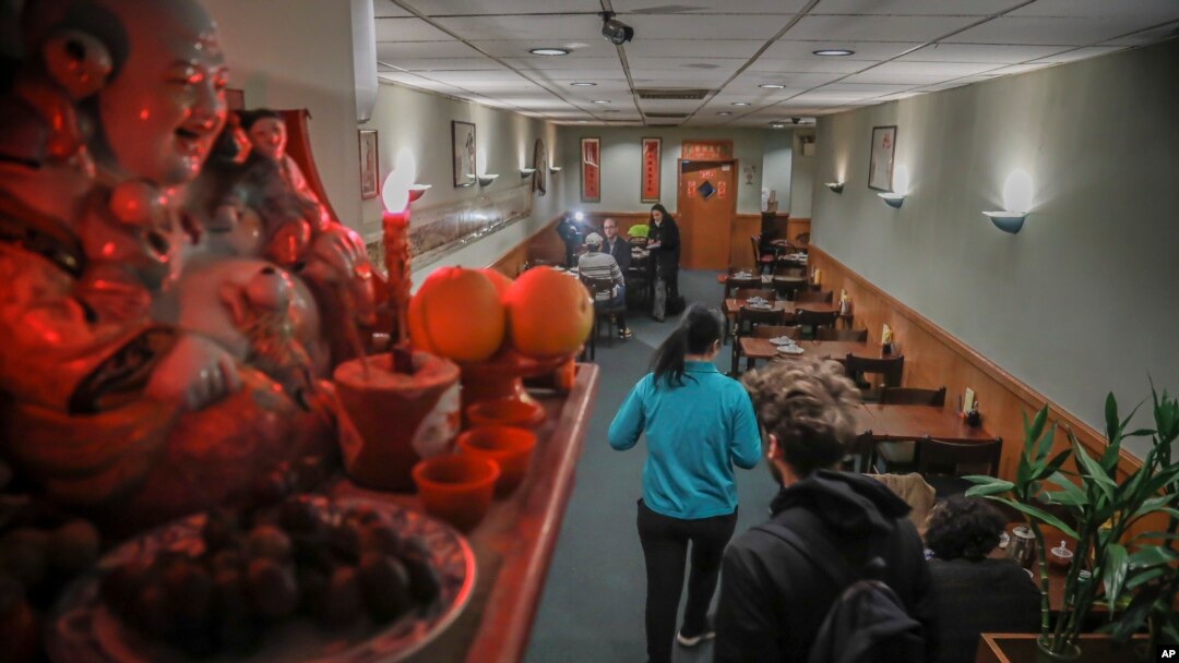 A Buddhist prayer shrine sits on a shelf over-looking a near empty Vegetarian Dim Sum restaurant in New York's ChinaTown, usually bustling with afternoon customers, Thursday Feb. 13, 2020, in New York. Chinatown has seen a decline in customers amid fears 
