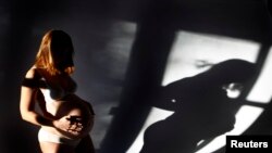 Pregnant Sabine Heinrich (36) is pictured while posing in her living room in Eichenau, December 12, 2012.