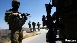 Israeli soldiers patrol during operation to locate three missing teenagers, in the West Bank city of Hebron, June 18, 2014.