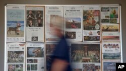 FILE - Some front pages and section fronts of the Orange County Register are seen in the newsroom in Santa Ana, Calif., Dec. 27, 2012. 